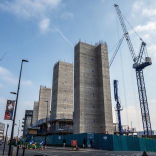 Construction site with several concrete structures and a crane.