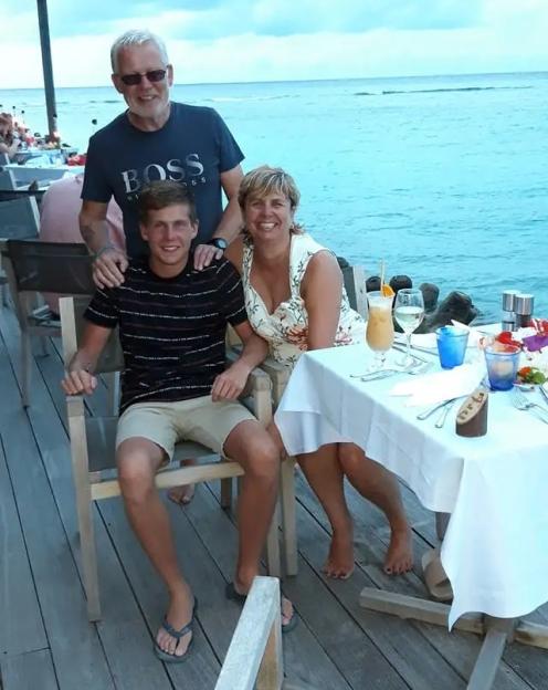 Tina Bauld, her husband Tom Bauld, and their son Gregor Bauld, sitting at a table near the ocean.