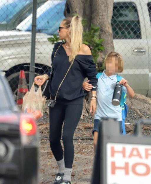 A blonde woman and a child walking.