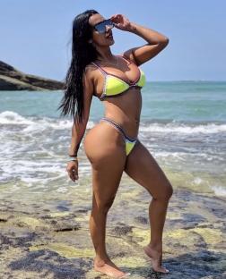 Woman in yellow bikini on beach.