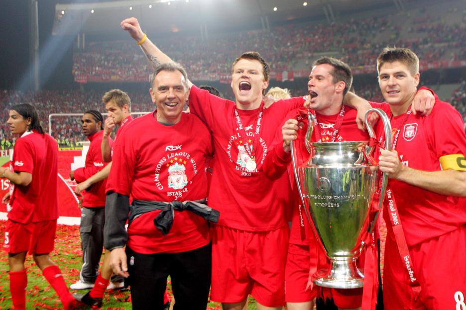 Liverpool's coach Alex Miller and players John Arne Riise, Jamie Carragher, and Steven Gerrard celebrating with the Champions League trophy.