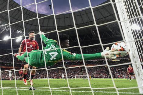 Andre Onana, Manchester United's goalkeeper, diving to try and stop a goal during a soccer match.