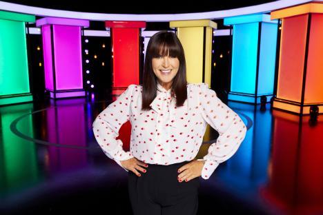 Anna Richardson posing in front of a colorful set.