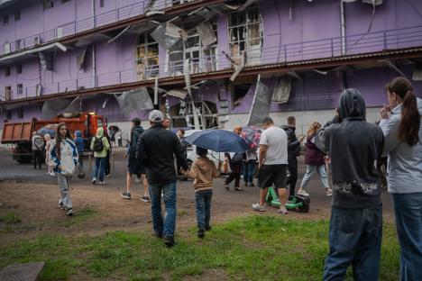 People walk past a damaged building in Kyiv, Ukraine, after a Russian drone strike.
