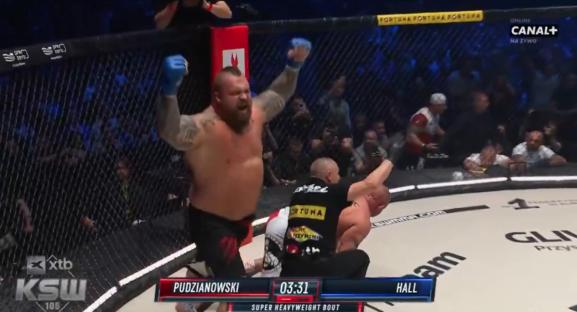 Eddie Hall celebrating a victory in a mixed martial arts match.