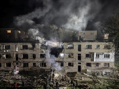 Apartment building damaged by a drone strike at night.