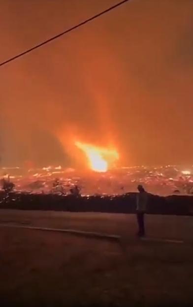 Person watching a large fire.