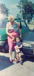 Woman and child standing by cars.