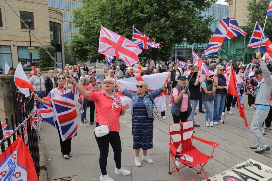 Protestors holding British flags demonstrate against migrants.