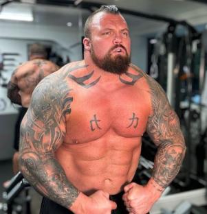 Eddie Hall, shirtless, showing off his tattoos and physique.