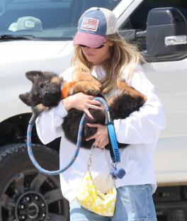Sydney Sweeney holding a German Shepherd puppy.