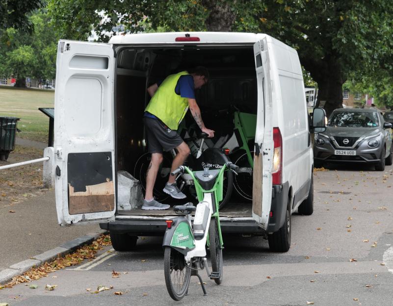 A worker loading Lime bikes into a van.