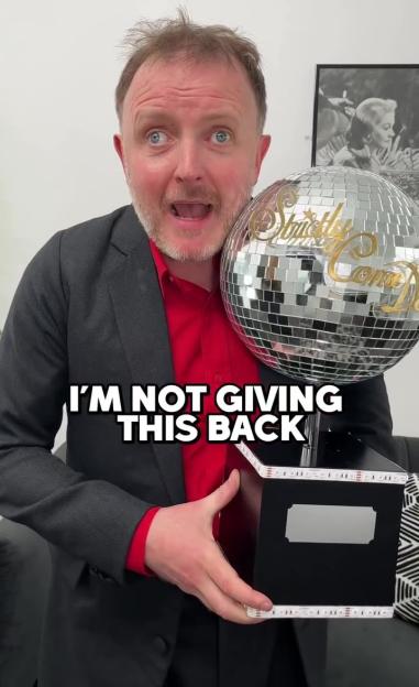 Chris McCausland holding the Strictly Come Dancing glitterball trophy.