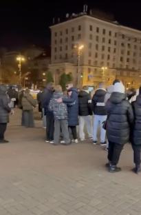 A group of people standing outside at night in Kyiv, Ukraine.
