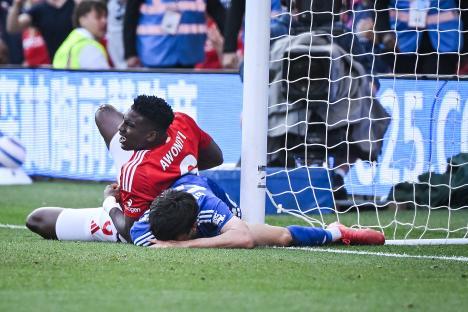 Two soccer players colliding near the goal.
