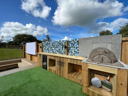 Outdoor kitchen with pizza oven and outdoor cinema screen.