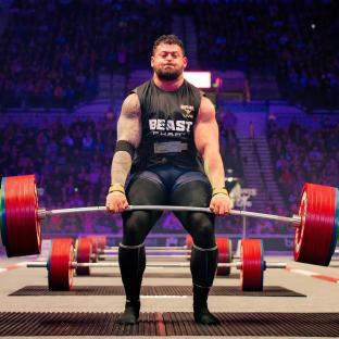 Strongman lifting a heavy barbell.