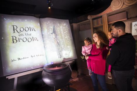 Family watching a projection of *Room on the Broom* at Chessington World of Adventures.