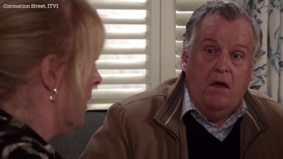 Still image from Coronation Street showing a man and woman in conversation.