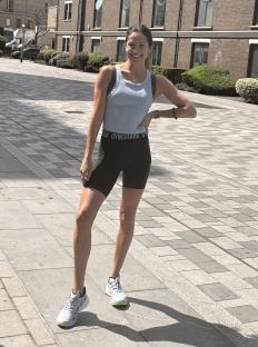 Woman in athletic wear standing outdoors.