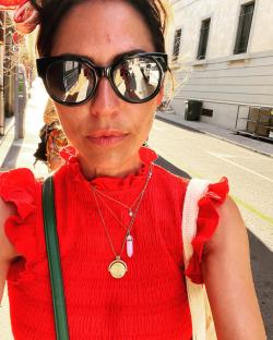 Woman wearing sunglasses and a red top.