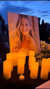 Memorial candles and a portrait of a woman.