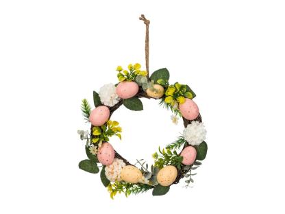 Easter wreath with pink and yellow eggs and flowers.