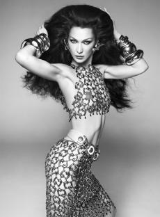 Bella Hadid on the cover of British Vogue, wearing a chainmail top and skirt.
