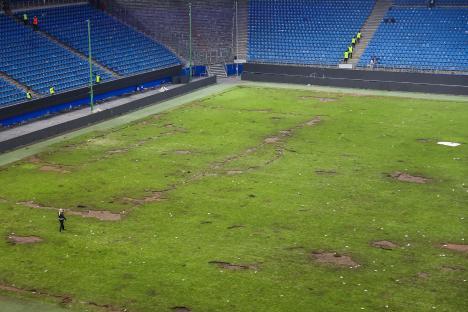 Damaged soccer field in a stadium after a pitch invasion.