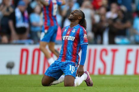 Eberechi Eze of Crystal Palace kneeling in joy after a match.