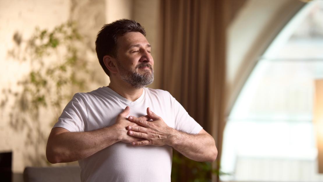 Middle-aged man practicing mindfulness at home.