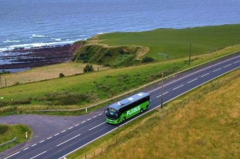 Aerial view of a FlixBus driving on a coastal road.