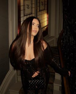 Woman in black lace dress on staircase.