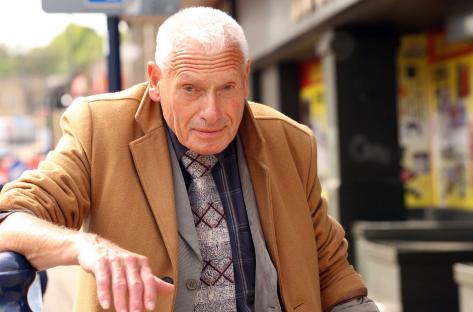 Photo of a man in a brown coat.