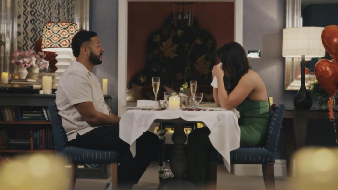 A man and a woman on a date, the woman is crying into a tissue.