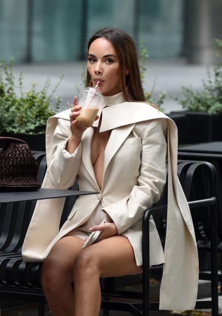 Chelsee Healy, Hollyoaks actress, sits outside drinking from a cup.
