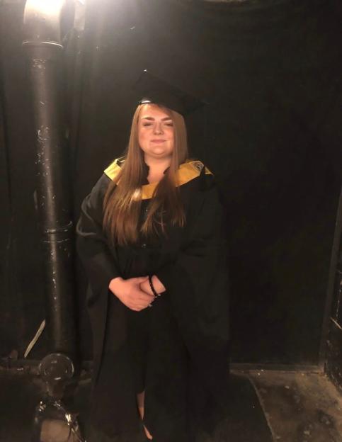 Woman in graduation gown.