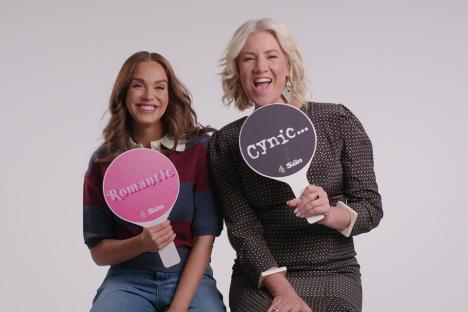 Two women holding signs that say 