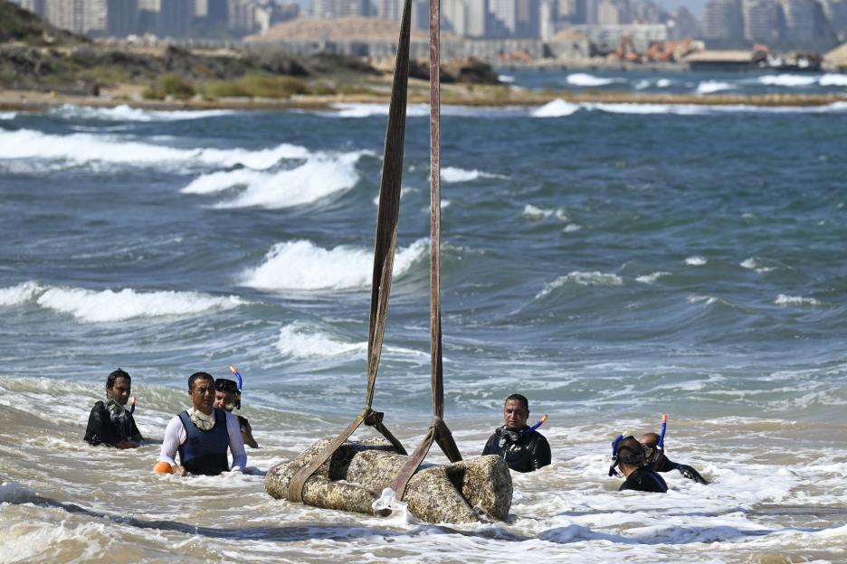 Divers recovering a statue from the sea.
