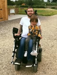 Man in wheelchair with young child.