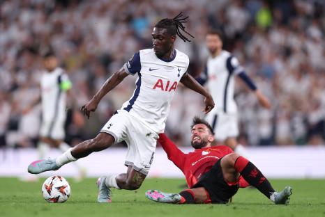 Yves Bissouma of Tottenham Hotspur challenges Bruno Fernandes of Manchester United during a soccer match.