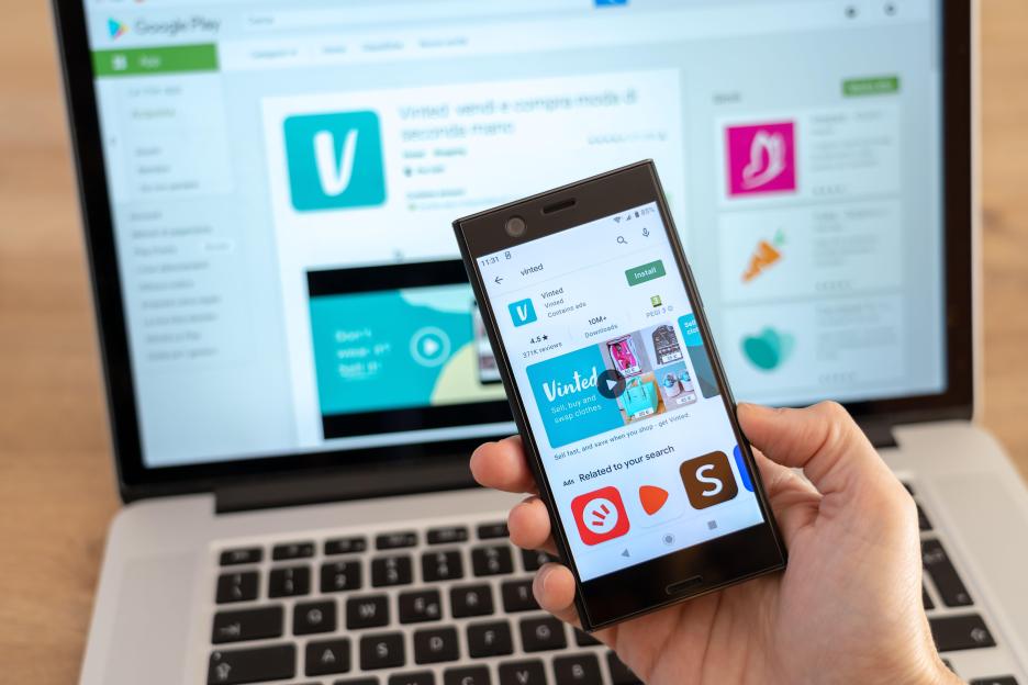 Person installing Vinted app on their phone.