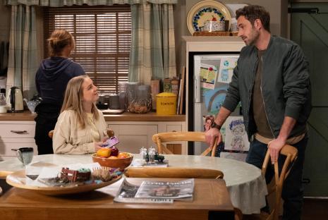 Scene from Emmerdale showing John Sugden and Belle Dingle in a kitchen.