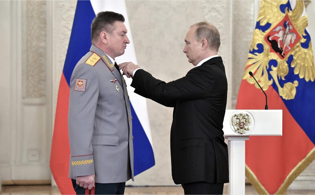 Vladimir Putin pinning a medal on Colonel General Alexander Lapin.