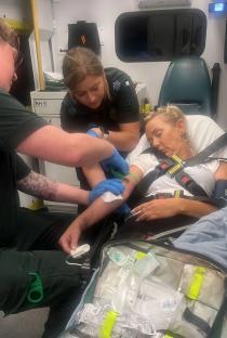 Paramedics treating a patient in an ambulance.