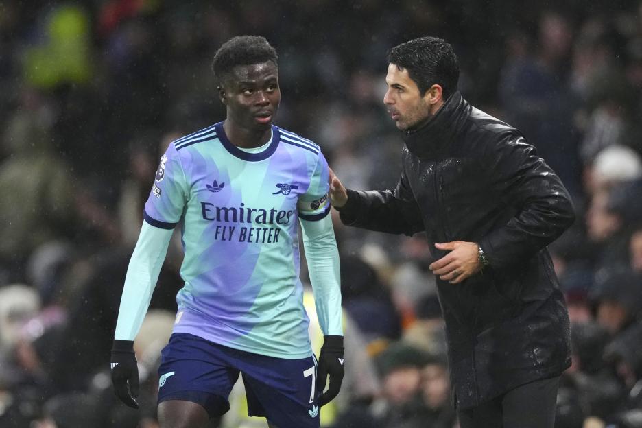 Mikel Arteta speaking with Bukayo Saka.