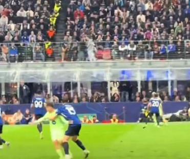 Barcelona soccer player tackled by opponents, with stadium crowd in background.