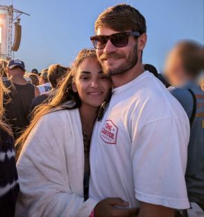 Couple embracing at an outdoor music festival.