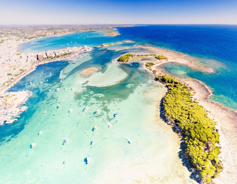 Aerial view of boats moored in the clear sea near Porto Cesareo, Salento, Apulia, Italy.