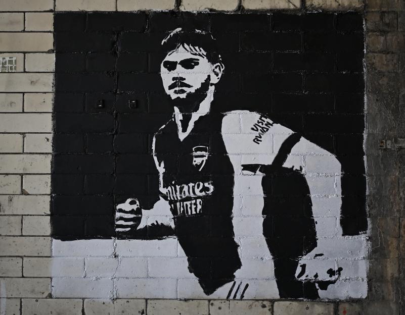 A black and white mural of Billy Vigar in an Arsenal kit.